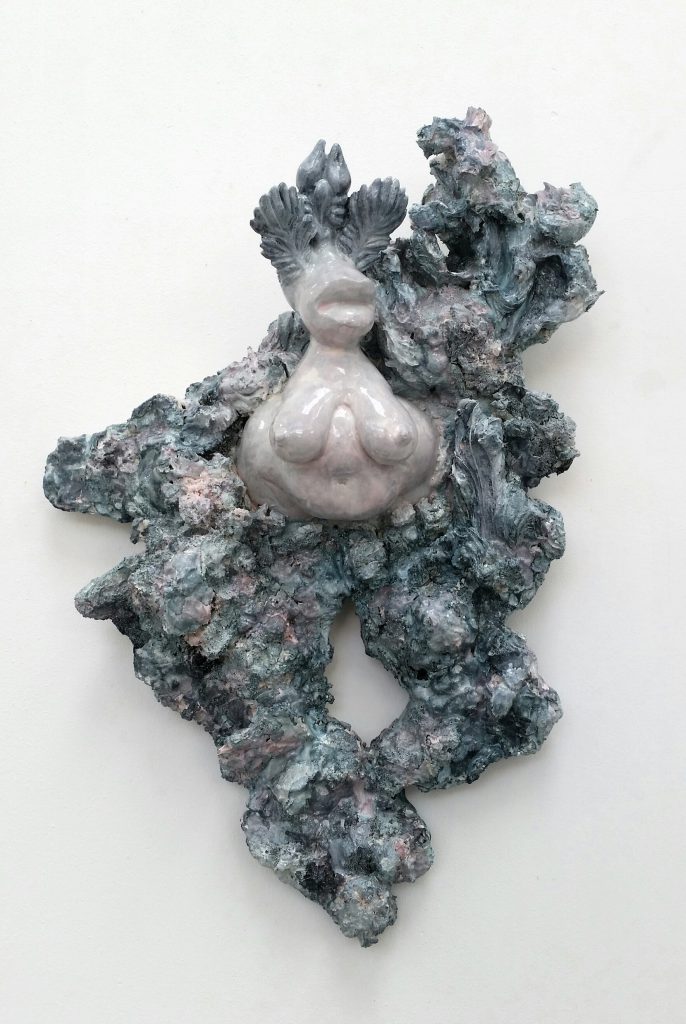 miriam lenk wolkenfee 2018 acrystal plaster a female torso rises out of a relief of figurine fragments and plaster chunks. the torso is light pink, the chunks are painted grey blue