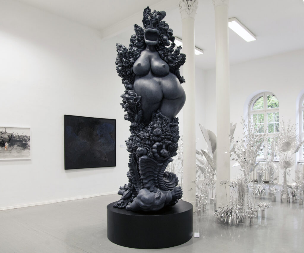 miriamlenk janusfee 2015. Epoxidharz blaugrau patiniert. abstrahierter, janusköpfiger torso einer frau inmitten wild wucgernder ornamente,pflanzen und mischwesen aus frau und tier.ausstellung chimera im kunstquartier bethanien berlin 2019 .