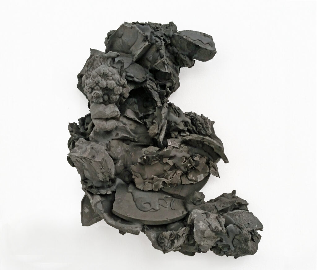 A black relief made of fragments and drops. From this emerges an abstracted head with baroque headdress that looks as if it has been through a night of partying. The title_ Monday Blues refers to this. 